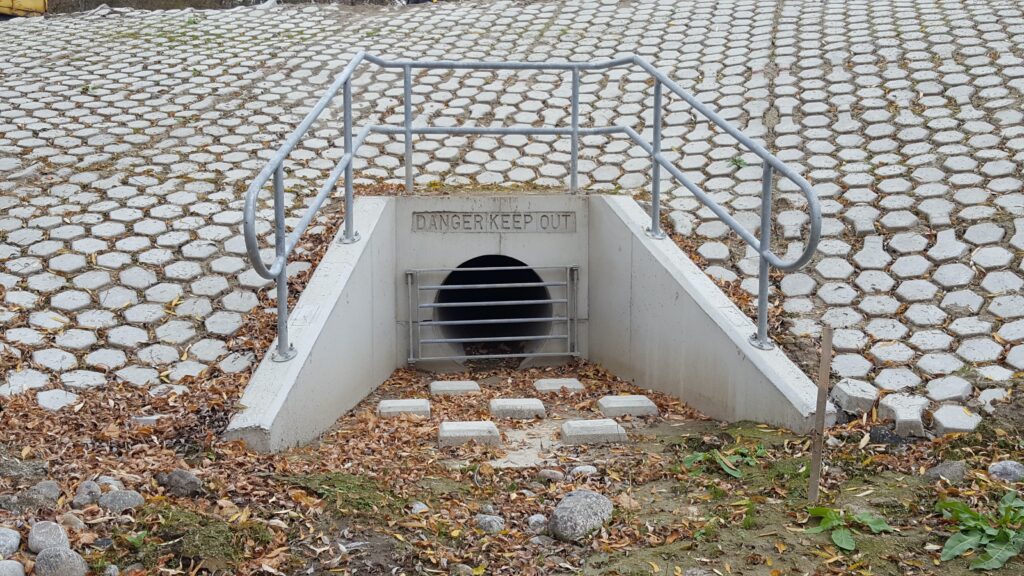 concrete drainage tunnel surrounded by concrete blocks on the ground