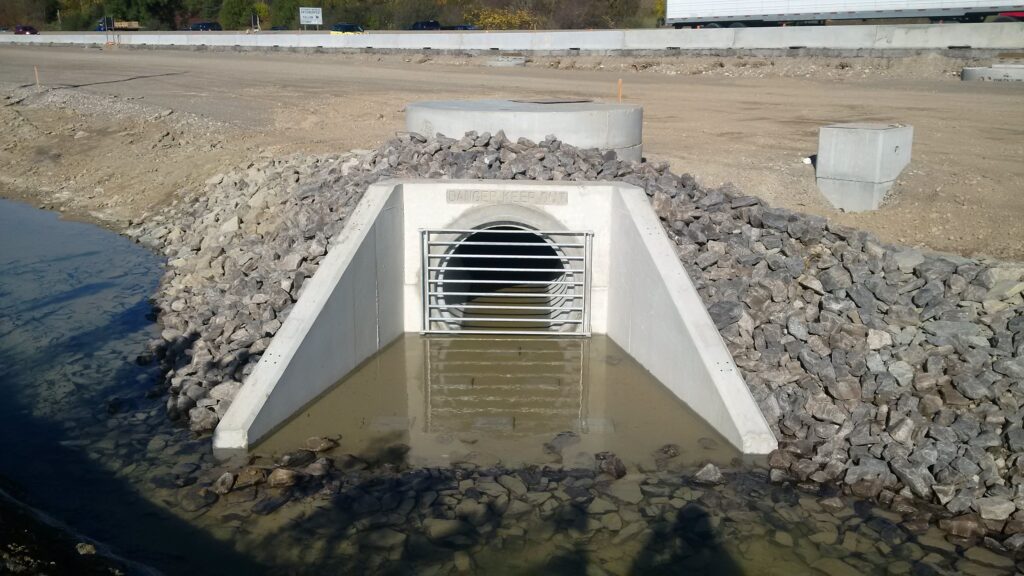 concrete drainage tunnel with headwall under road under construction